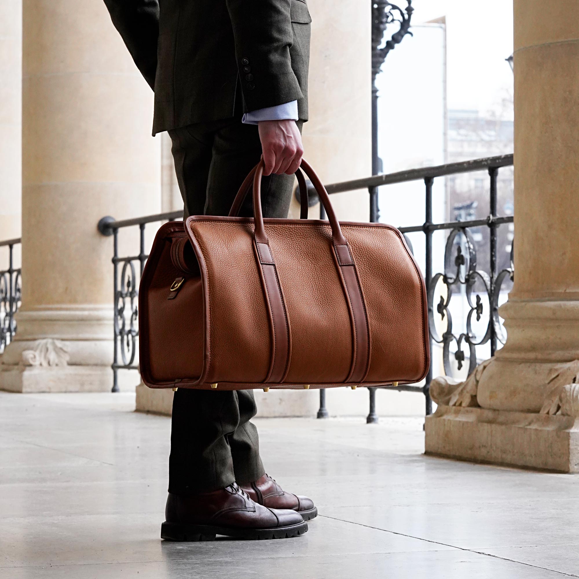 Mann in Anzug mit cognac farbenem Leder Weekender